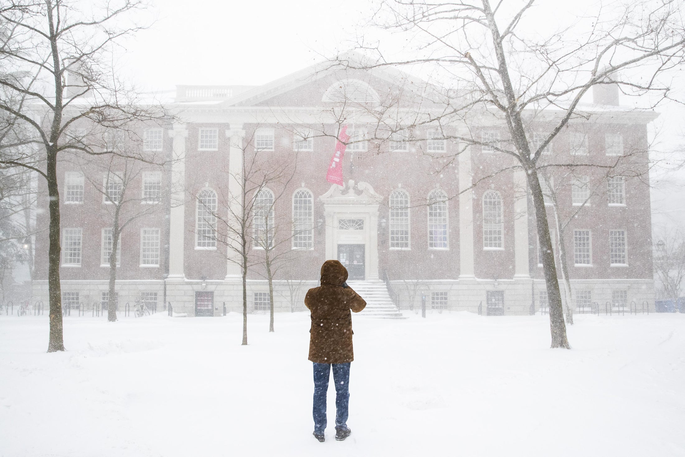 A man takes pictures of the snow on campus at Harvard University during a snowstorm on January 29, 2022 in Cambridge, Massachusetts Adam Glanzman:Getty Images
