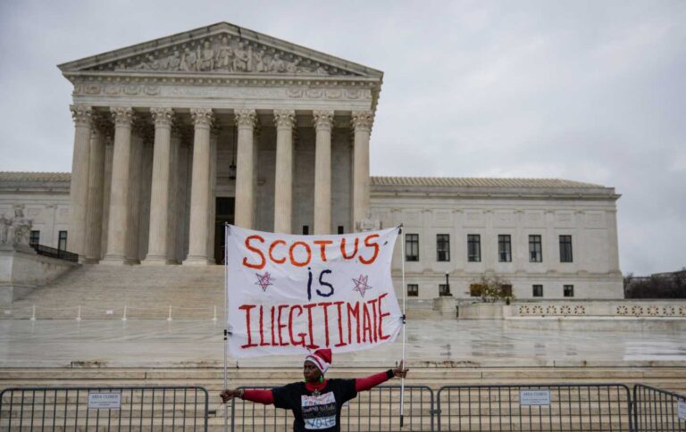 Activist holds sign in front of Supreme Court, credit Drew Angerer, Getty
