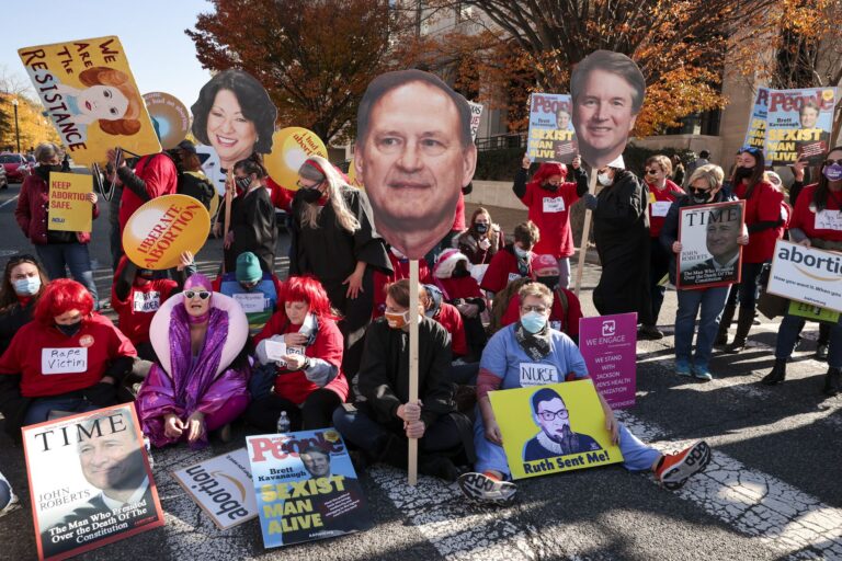 Activists hold photos of US Supreme Court justices, credit Chip Somodevilla, Getty Images