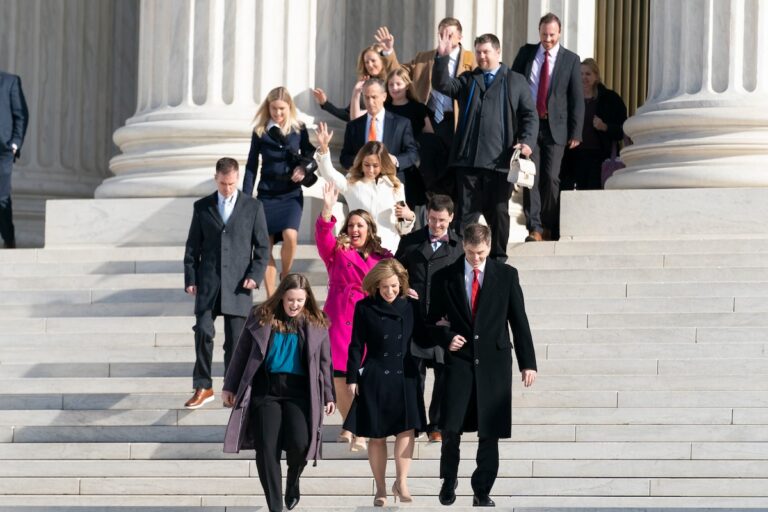 Lorie Smith, a graphic artist and website designer in Colorado, center in pink, accompanied by lawyers from Alliance Defending Freedom, walks out of the Supreme Court, credit Andrew Harnik, AP