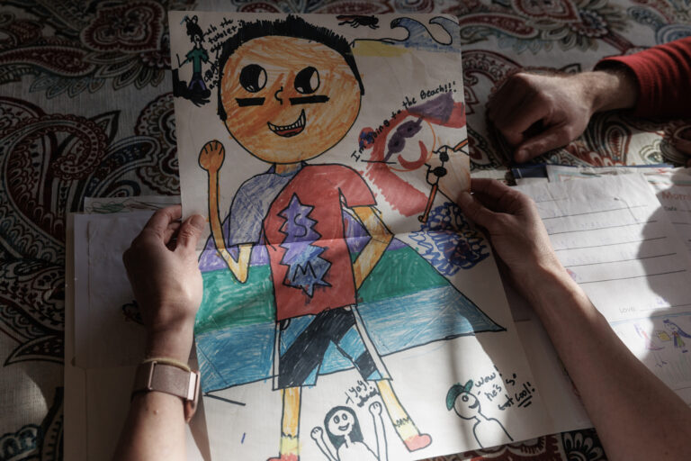 Parents look at a self-portrait their son drew expressing his identity, credit Shelby Tauber. The Washington Post, Getty Images